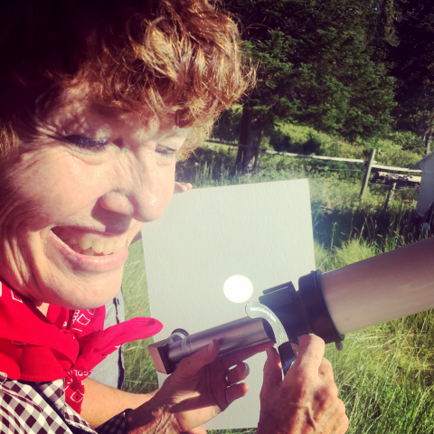 Mary's smiling face while operating a small telescope