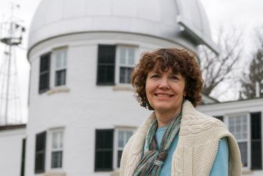 Mary Hudson smiling in front of a observatory building at Dartmouth College